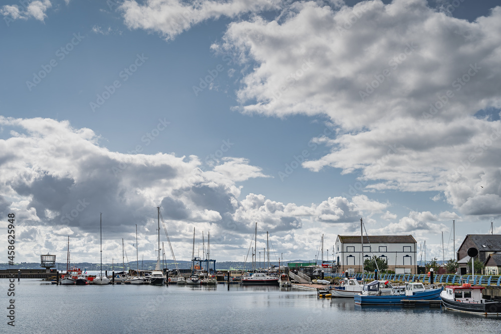 Yachts, sailboats and fishing boats moored in small, beautiful marina in Carrickfergus town, Northern Ireland