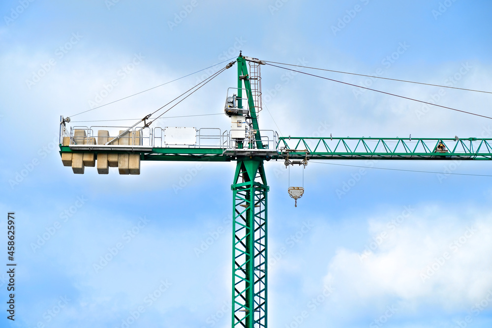 Green crane on a construction site, detail of the frame with counterweight.