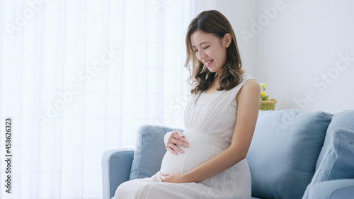 部屋でリラックスする若い妊婦