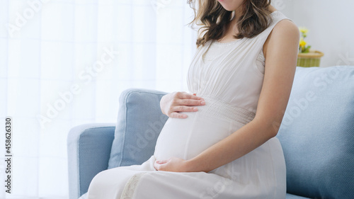 部屋でリラックスする若い妊婦