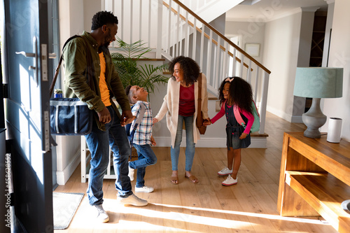 Fotografie Happy african american family standing in hallway, returning back home