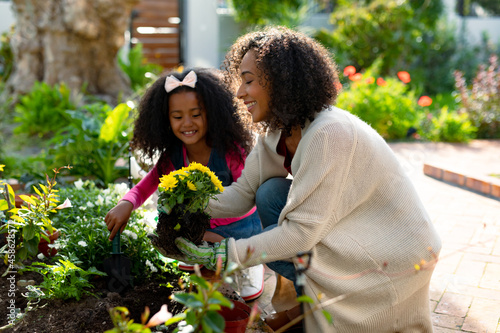 Fotótapéta Happy african american mother and daughter planting flowers