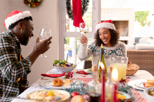 Happy african american couple making toast at christmas table