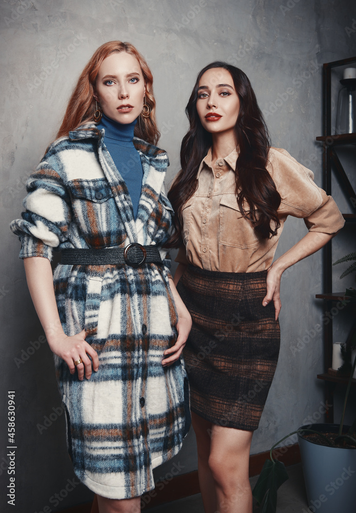 Retro fashion: two beautiful young women indoors. Vintage portrait of attractive girls in seventies style