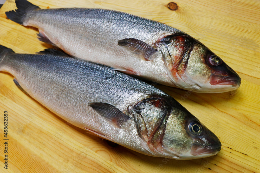 fresh atlantic sea bass on a wooden board to make fillet fresh atlantic sea bass on a wooden board to make fillet