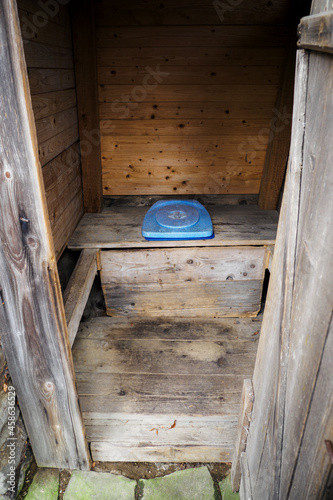 Wooden outdoor toilet with plastic seat.