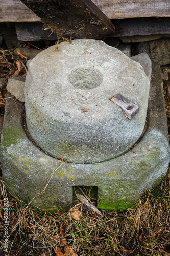 Old millstone lying on the ground.