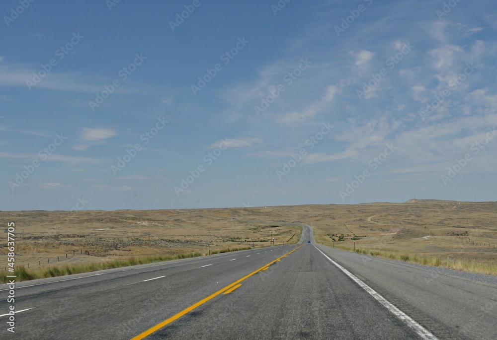 Straight paved road along Wyoming landscape