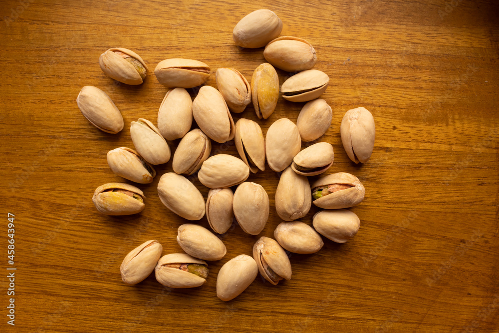 top view of many pistachios on a wooden background