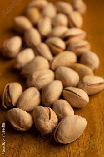 close up of many pistachios on a wooden background