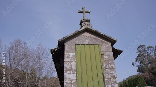 Traveling of stone granary with parts of green wood and trees in the background (low angle front view and full cross) photo