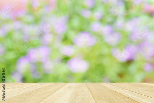 Empty top wooden table on soft focus blurred flowers field for background