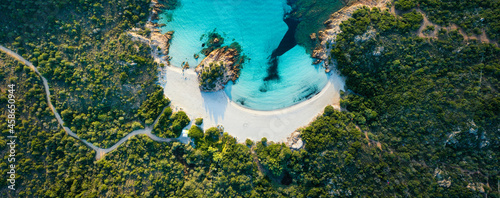 View from above, stunning aerial view of a green coast with the beautiful Prince Beach (Spiaggia del Principe) a white sand beach bathed by a turquoise water. Sardinia, Italy.