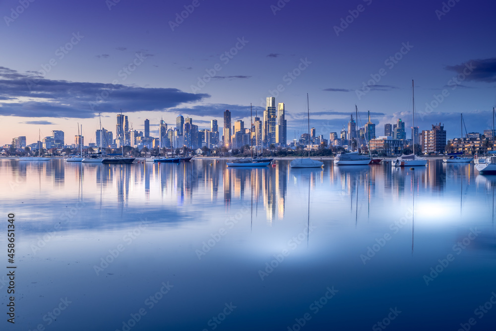Fototapeta premium Melbourne, Victoria, Australia - August 2021: Melbourne city skyline at dusk, from the Royal Melbourne Yacht Squadron marina on Port Phillip Bay in St Kilda.
