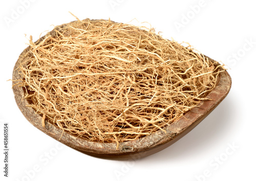 dried vetiver roots in the wooden bowl, isolated on the white background