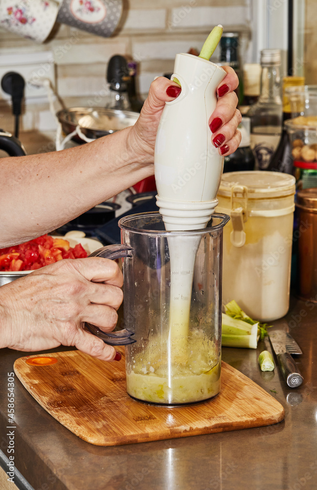Cook grinds the puree fennel with hand blender Cook grinds the puree fennel with hand blender