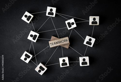 teamwork concept. successful cooperation network, team structure. wooden cube blocks with human icons on black background. with copy space for business design