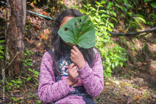 Little girl with green leaf on her face