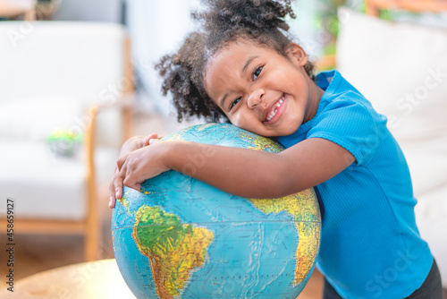 Young girl looking at a globe in library