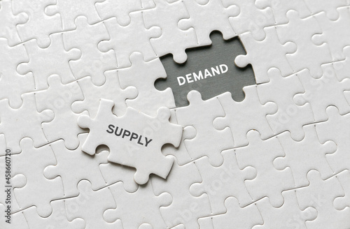 Fotografia Selective focus of an empty space of jigsaw puzzle written with Demand and a piece of jigsaw puzzle written with Supply