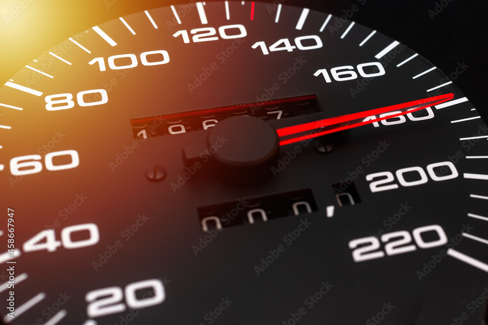 Car speedometer. Auto car speedometer shows 180 km h or miles.Closeup shot,dark black background.Automobile dangerous speed concept Car speedometer. Auto car speedometer shows 180 km h or miles.Closeup shot,dark black background.Automobile dangerous speed concept