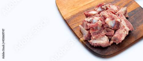 Raw pork ribs on wooden cutting board on white background.