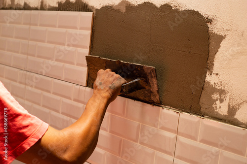 House renovation, laying ceramic tles on the wall photo