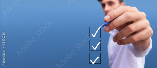 Young man checking boxes with list of 3 options on blue background