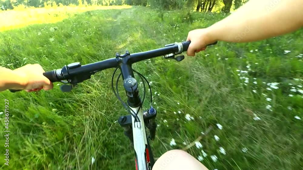 Man riding a bicycle in a field on a green grass Man riding a bicycle in a field on a green grass