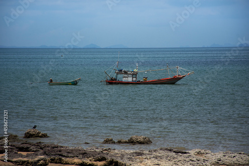 Thai local wooden small fishing boat float in sea ocean at Sairee sand beach in Gulf of Thailand and wait catch fish and marine life in night time in Chum phon city in Chumphon province of Thailand