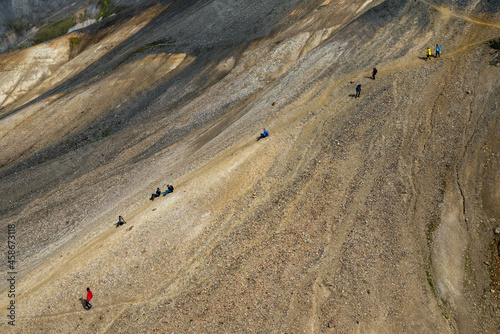 Hikers in volcanic mountains of Landmannalaugar in Fjallabak Nature Reserve. Iceland