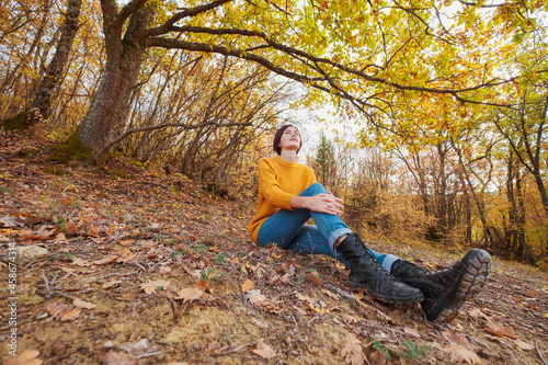 Woman hiking looking at scenic view of autumn foliage landscape.
