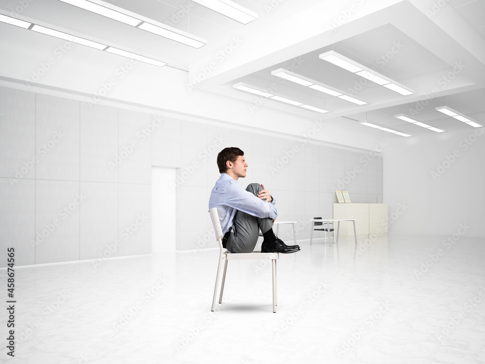 scared businessman on a chair in office scared businessman on a chair in office