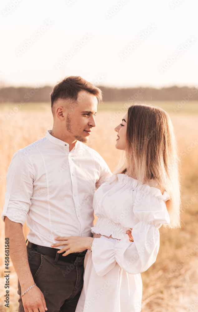 A young couple man and woman hug with tenderness in nature in the summer. Lovers A young couple man and woman hug with tenderness in nature in the summer. Lovers