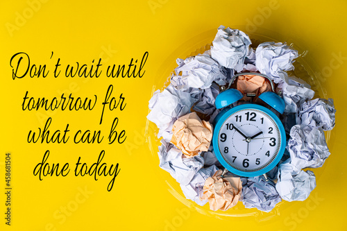 Business concept. Layout of alarm clock, crumpled papers with text depicting procrastinate. Quote