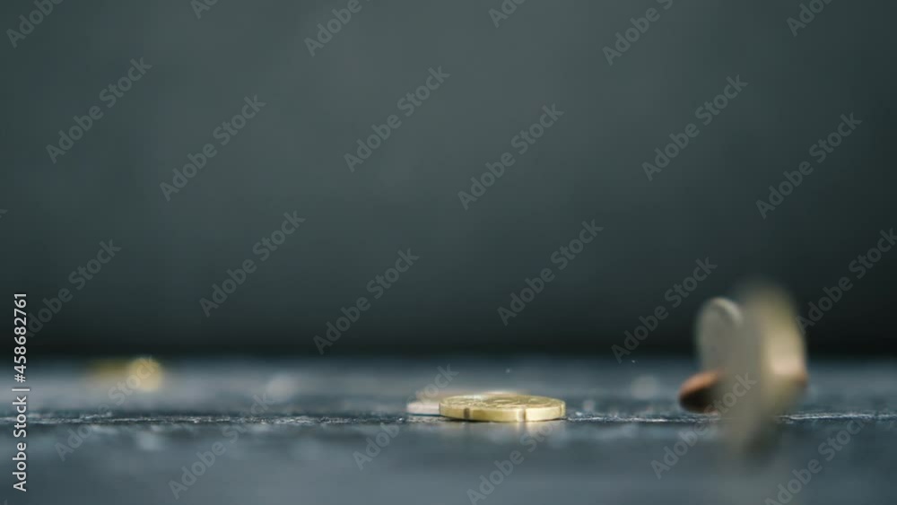 Coins from different countries fall in slow motion. Black background, close-up Coins from different countries fall in slow motion. Black background, close-up