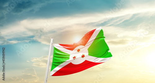 Burundi national flag cloth fabric waving on beautiful sky - Image