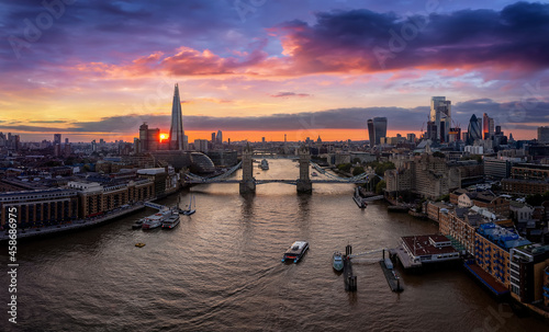 Aerial view to the urban skyline of London with the Tower Bridge and skyscrapers of the City during a colorful sunset