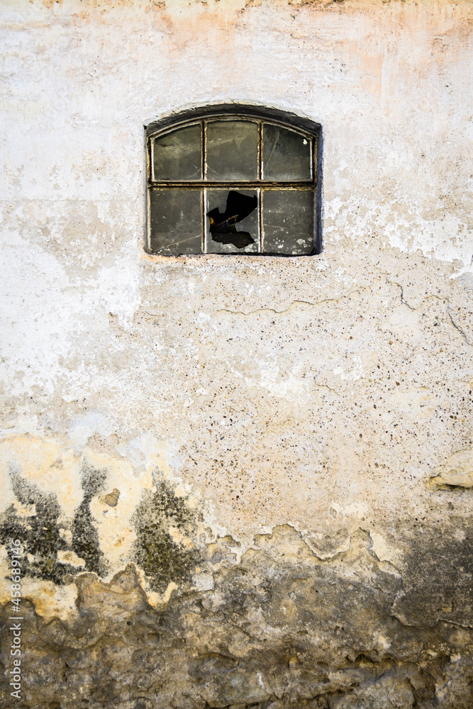 Old broken window on abandoned rural warehouse