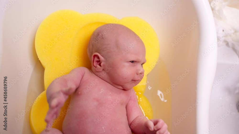 Hygiene of infants and care for newborns, bathing in a bath with warm
