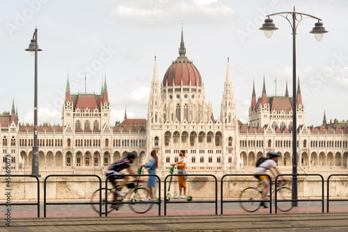 Blurred bicyclists on a Bike Lane against Hungarian parliament building