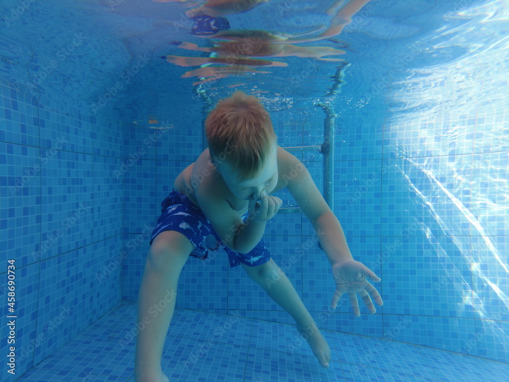 Larnaca, Cyprus - September 2021: A child dives into the pool. Summer vacation in the pool. A boy with a circle jumps into the pool.