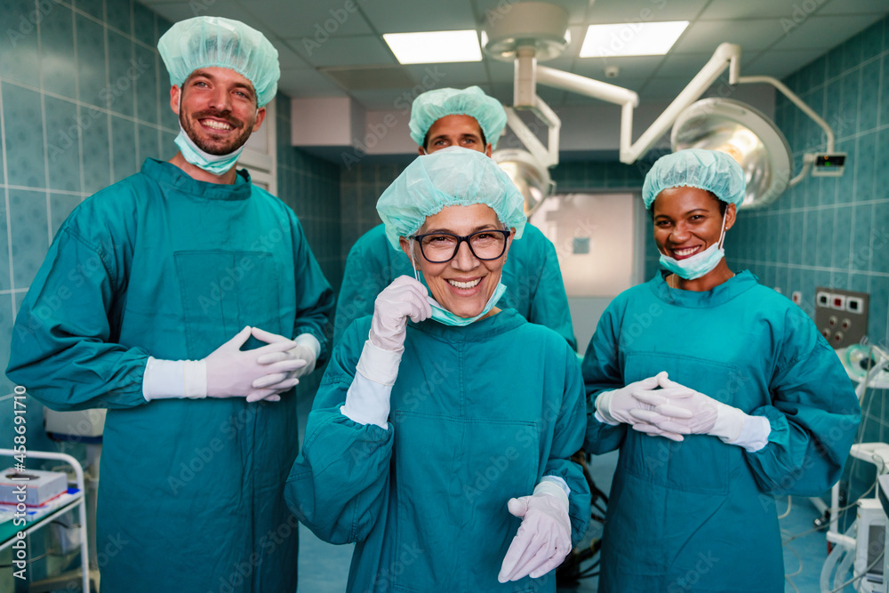 Portrait of successful team of surgeon standing in operating room, ready to work