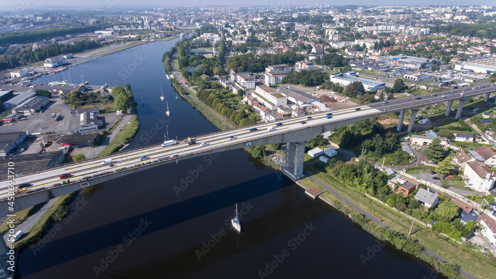 CAEN, FRANCE-SEPTEMBER 2021: Viaduc de Calix on the canal de caen. The largest bridge in Caen, an important road E46 for cars. A photo from the drone, in the phone is buildings and greenery