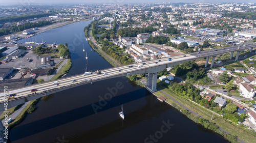 CAEN, FRANCE-SEPTEMBER 2021: Viaduc de Calix on the canal de caen. The largest bridge in Caen, an important road E46 for cars. A photo from the drone, in the phone is buildings and greenery