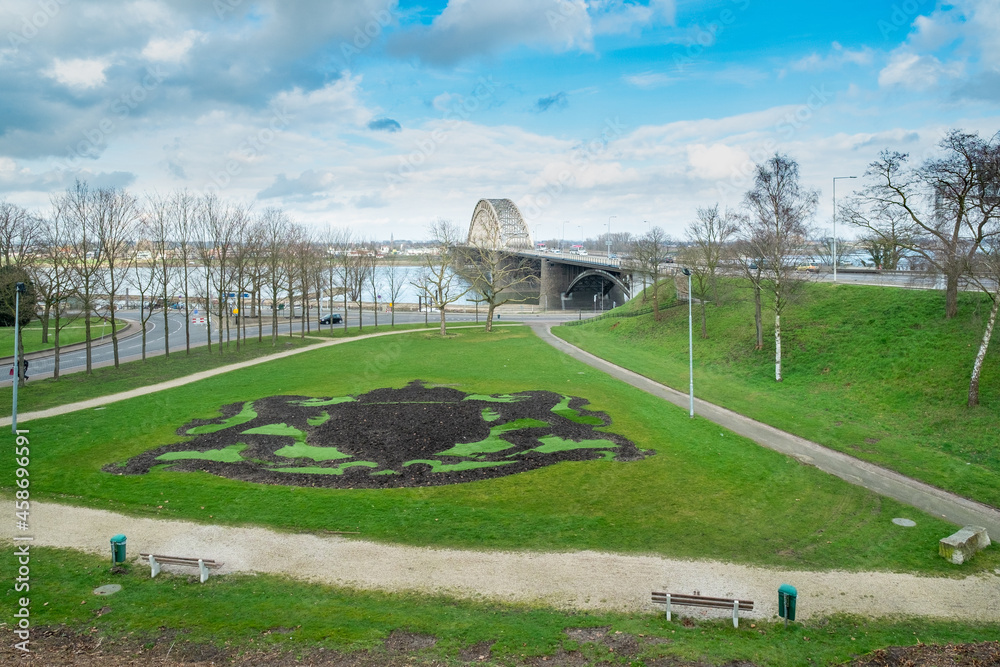 Fototapeta premium View of the Waalbrug near Nijmegen in the foreground is the coat of arms of Nijmegen cut out in the grass, Nijmegen, Gelderland Province, The Netherlands