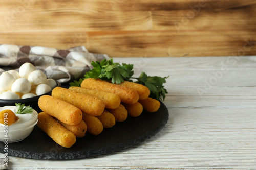 Concept of tasty food with cheese sticks on white wooden table
