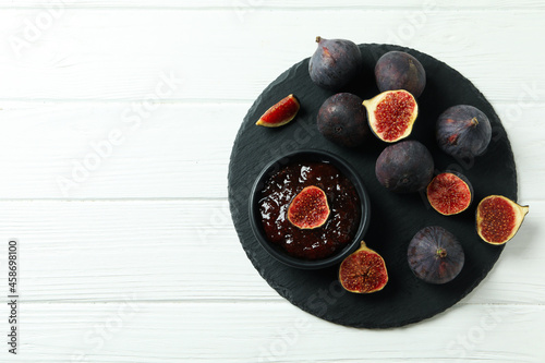 Tray with fig jam and ingredients on white wooden background