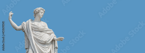 Old roof statue of a beautiful Renaissance Era woman philosopher and poet with her hand up as she declares something in Potsdam at white blue sky background and copy space, Germany.