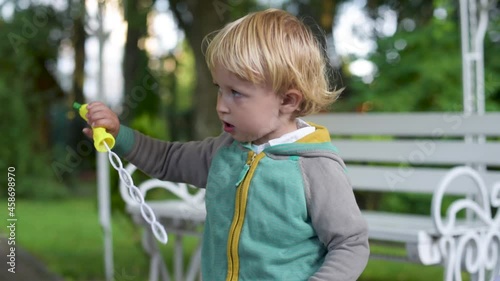 Boy Blowing Bubbles. A little Boy is having fun Blowing party bubbles at the camera. Blowing Bubbles in the Garden. 
